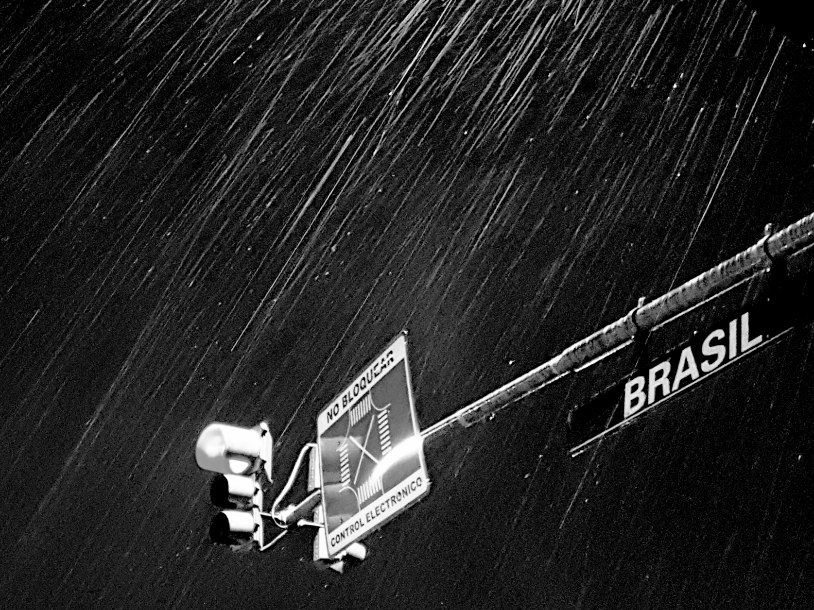Rain falling over a sign in a dark street scene